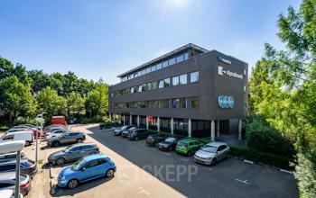 Exterieur van kantoorpand op Westboek 36-66 in Breda Noord-West. Parkeerplaats vol voertuigen voor toegang tot kantoorruimte huren.