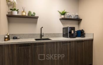 Kleine pantry in een kantoorpand aan Takkebijster 57A in Breda Oost-Brabantpark met een koffiezetapparaat en wastafel. Voor een inspirerende werkplek kun je deze kantoorruimte huren.