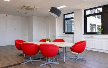 Eigentijdse kantoorruimte huren met rode stoelen en moderne verlichting in het kantoorpand op Druivenstraat 25-31 in Breda Oost.