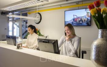check-in desk reception people flowers tulips screen