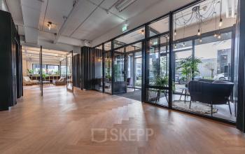 Kantoorpand aan Rietbaan 2-12 in Capelle aan den IJssel met glazen wanden, houten vloer en moderne zitplekken. Ideaal voor kantoorruimte huren in een stijlvolle omgeving.