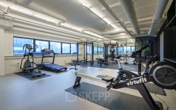 Interieurfoto van een ruime fitnessruimte in het kantoorpand Rietbaan 2-12 te Capelle aan den IJssel, uitgerust met moderne fitnessapparatuur. Voorzieningen ideaal voor huurders van kantoorruimte.