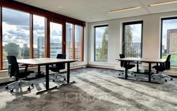 Kantoorruimte huren op Fascinatio Boulevard 562 in Capelle aan den IJssel, met twee bureaus en stoelen, grote ramen met uitzicht op de stad.