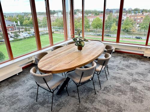 Vergaderruimte in een kantoorpand aan de Fascinatio Boulevard 562, Capelle aan den IJssel, met een grote houten tafel en ramen met uitzicht op groen.