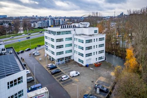 Exterieur van het kantoorpand op Rhijnspoor 209-263, Capelle aan den IJssel, omgeven door parkeerplaatsen en omringende stedelijke omgeving.