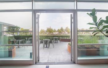 Uitzicht vanaf een lichte kantoorruimte op Fascinatio Boulevard 522 in Capelle aan den IJssel, met glazen deuren naar een buitenterras. Ideaal voor kantoorruimte huren met een natuurlijke omgeving.