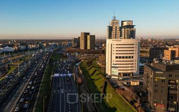 Exterieur van een kantoorpand aan Rivium Quadrant 75 in Capelle aan den IJssel, met uitzicht op nabijgelegen wegen en andere kantoren. Ideale locatie voor kantoorruimte huren dichtbij infrastructuur.