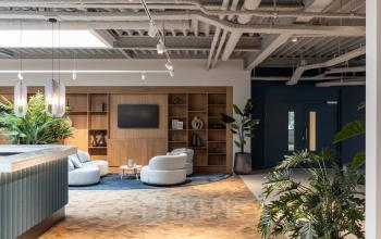 Moderne kantoorruimte op Essebaan 63, Capelle aan den IJssel, met stijlvolle zitgedeelte en groene planten. Ideaal om te huren als kantoorpand met comfortabele werkplekken.