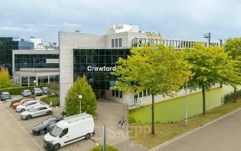 Exterieur van kantoorpand aan Vlierbaan 20, Capelle aan den IJssel, met parkeerplaatsen aan de voorkant. Ideaal voor kantoorruimte huren.