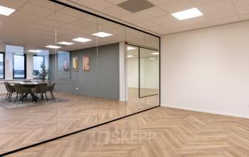 Moderne kantoorpand op Vlierbaan 20 in Capelle aan den IJssel met glazen wanden en houten vloer, ideaal voor kantoorruimte huren.