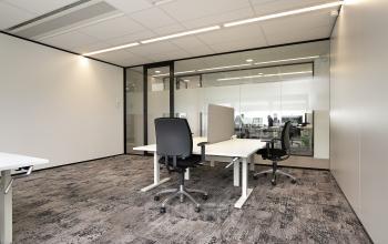 Moderne kantoorruimte te huur op Rijnzathe 6, De Meern, met glazen wanden en verstelbare bureaus in een lichte omgeving.