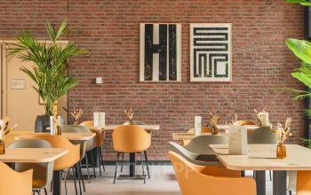 Moderne kantoorruimte huren in De Meern met stijlvolle zitplaatsen en sfeervolle decoratie tegen een bakstenen muur.