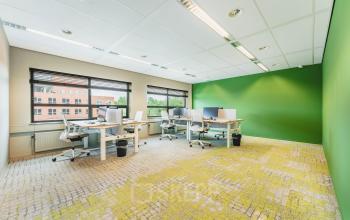 Moderne kantoorruimte te huur op Rijnzathe 12 in De Meern, compleet met bureaus en ergonomische stoelen in een lichte omgeving met groene accenten.