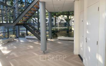 Een lichte entree van het kantoorpand aan Delftechpark 17-19 in Delft met grote ramen en een trap. Ideaal voor kantoorruimte huren met een moderne uitstraling.