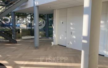 Lichte en open entree van een kantoorpand op Delftechpark 17-19 in Delft, met houten vloer en moderne, strakke afwerking. Ideale ruimte voor wie kantoorruimte wil huren.