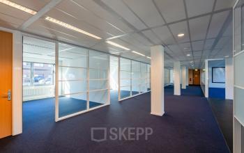 Ruime kantoorruimte met glaswanden en zachte verlichting op Delftechpark 17-19, Delft, ideaal voor wie een kantoorpand wil huren.