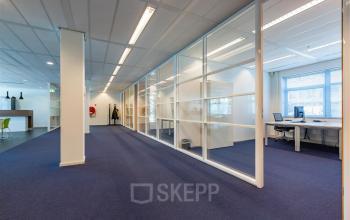 Kantoorruimte huren op Delftechpark 17-19 in Delft met open indeling, witte wanden, grote ramen voor natuurlijk licht en blauw tapijt, inclusief bureaus en stoelen voor een productieve werkomgeving.