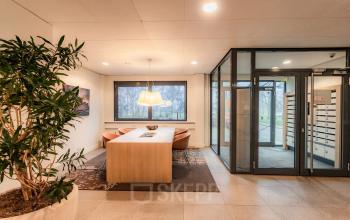 Gemeubileerd interieur van het kantoorpand op Marshalllaan 2 in Delft, met een vergadertafel, stoelen en planten. Ideaal voor bedrijven die kantoorruimte willen huren.