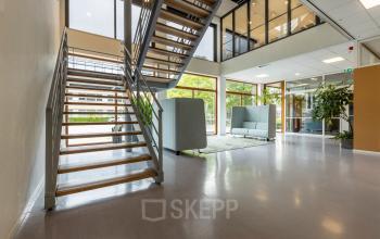 Moderne kantoorruimte huren op Delftechpark 9, Delft met ruime trappenhal, glazen wanden en stijlvolle zitbanken voor een open, lichte sfeer.