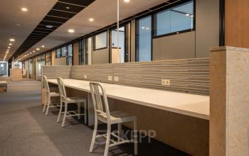 Moderne kantoorruimte huren op Delftechpark 9 in Delft, met lange werktafels en comfortabele stoelen, ideaal voor efficiënt kantoorwerk.