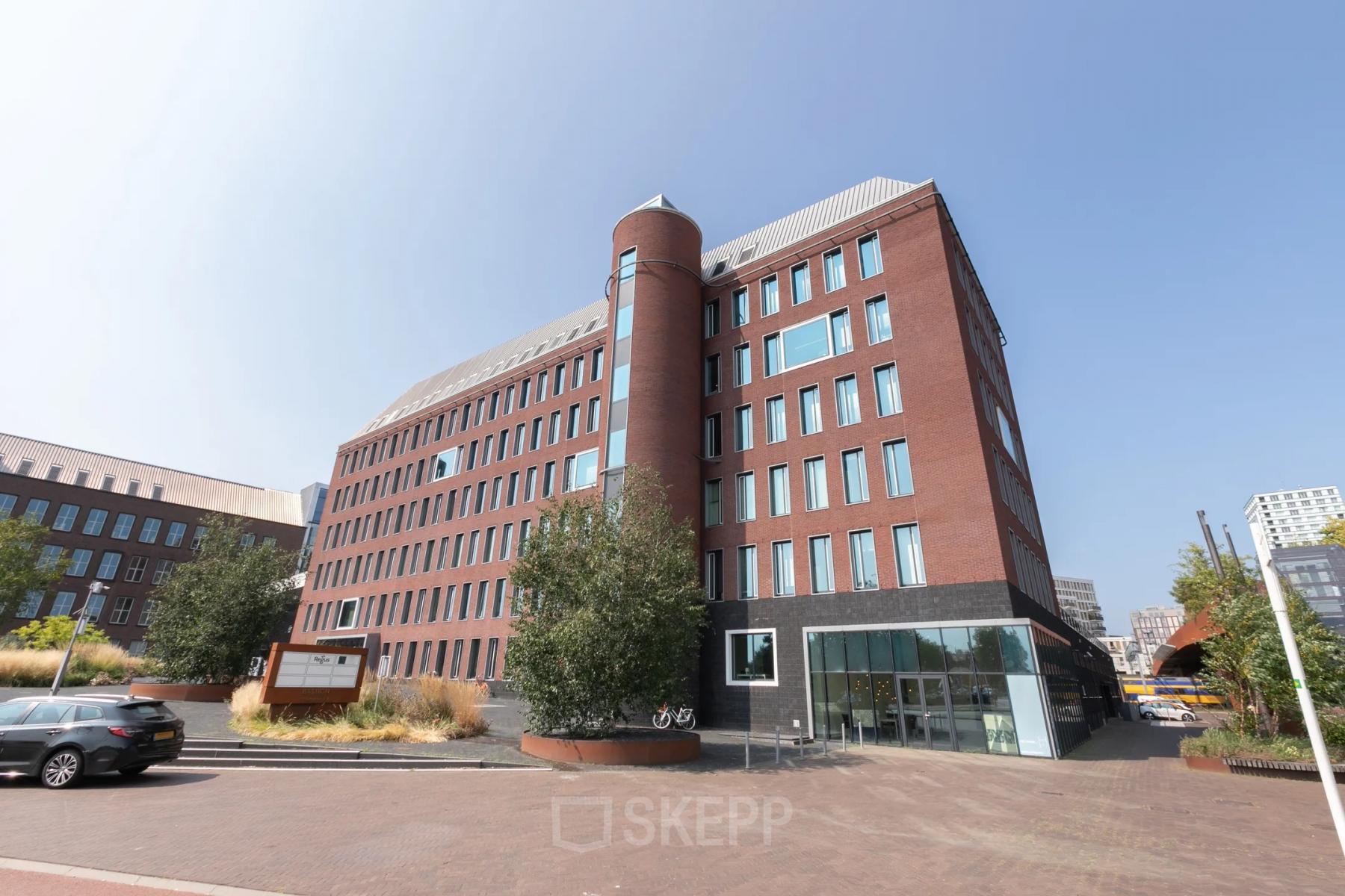 Kantoorgebouw op Willemsplein 2 in Den Bosch met markante ronde toren en bakstenen gevel. Ideale locatie voor kantoorruimte huren met ruime parkeergelegenheid.