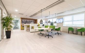 Moderne en lichte kantoorruimte in Den Bosch met open indeling en groene accenten, geschikt voor kantoorruimte huren.