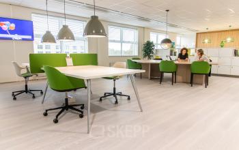 Moderne kantoorruimte in Pettelaarpark 84, Den Bosch met groen-witte meubels en werkende professionals.