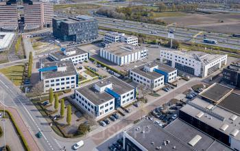 Luchtfoto van een kantoorgebouw op Europalaan 2 in Den Bosch, omringd door meerdere kantoren met parkeergelegenheid. Ideale locatie voor kantoorruimte huren.