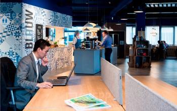 Kantoorruimte huren in Den Bosch aan de Europalaan 2 met mensen bezig aan werkprocessen. Sfeervol interieur met werkplekken en keukenfaciliteiten.