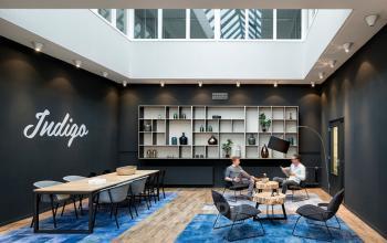 Stijlvolle vergaderruimte in kantoorpand aan de Europalaan 2, Den Bosch, met moderne meubels en lichtinval. Twee mensen in overleg aan tafel. Ideaal voor kantoorruimte huren.