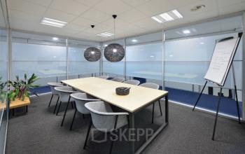 Moderne kantoorruimte huren aan de Europalaan 2 in Den Bosch met glazen wanden, designverlichting, en een lange tafel omringd door comfortabele stoelen, ideaal voor vergaderingen.