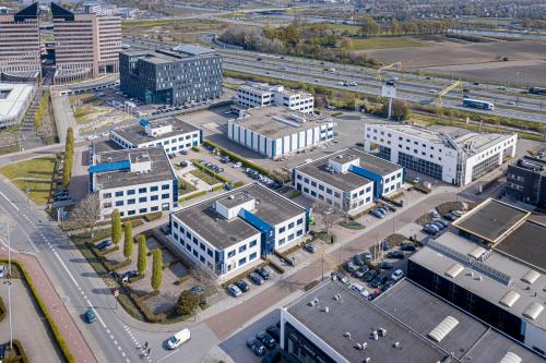 Luchtfoto van een kantoorgebouw op Europalaan 2 in Den Bosch, omringd door meerdere kantoren met parkeergelegenheid. Ideale locatie voor kantoorruimte huren.