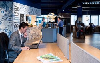 Moderne kantoorruimte huren op Amerikastraat 3 in Den Bosch met mensen die werken aan bureaus en in een pantry-omgeving.