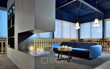 Moderne kantoorruimte in Den Bosch met een open haard en stijlvolle zitplaatsen. Ideaal voor huurders die op zoek zijn naar een inspirerende werkplek.