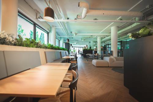 Modern ingericht kantoorpand op Hambakenwetering 1, Den Bosch, met warme houten vloeren en voldoende zitplek. Ideale kantoorruimte huren voor een inspirerende werkomgeving. Planten en grote ramen zorgen voor veel natuurlijk licht.