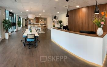 Moderne kantoorruimte met werkplekken en een receptie bij Stationsplein 91 in Den Bosch, ideaal voor bedrijven die een kantoor willen huren.