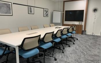 Moderne, goed verlichte vergaderruimte in kantoorpand aan Stationsplein 91, Den Bosch, met grote tafel en comfortabele stoelen