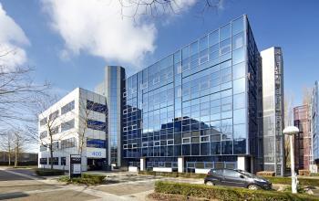 Modern kantoorpand aan de Bruistensingel 400 in Den Bosch, met glazen gevel en parkeerplaatsen voor het huren van kantoorruimte.