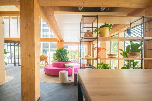 Moderne en lichte kantoorruimte huren in Den Bosch, op Hambakenwetering 1-kr, met houten accenten en kleurrijke meubels, ideaal voor creatieve werkplekken.