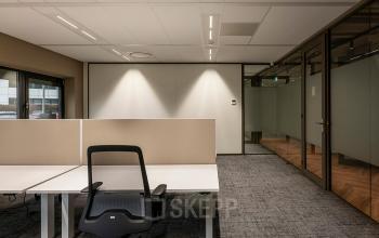 Functionele kantoorruimte huren op Pettelaarpark 110, Den Bosch met moderne werkplekken en glazen wanden voor vergaderingen en overleg. Veel lichtinval door grote ramen en neutrale kleuren voor een professionele uitstraling.
