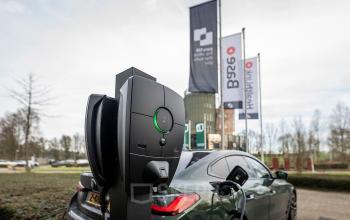 Exterieur van het kantoorpand op Pettelaarpark 110 in Den Bosch, met zicht op de parkeerplaats en een elektrische laadpaal. Ideale locatie voor kantoorruimte huren met moderne faciliteiten.