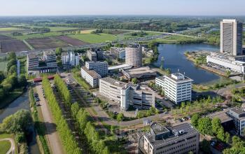 Luchtfoto van kantoor Pettelaarpark 110, Den Bosch, omgeven door groen en water, met meerdere moderne kantoorpanden zichtbaar.