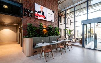 Moderne kantoorruimte in Den Bosch met open zithoek, veel daglicht en planten voor een ontspannen sfeer.