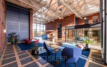 Kantoor op Hambakenwetering 5 in Den Bosch met een moderne inrichting. Gezellige lobby met stijlvolle meubels en veel natuurlijk licht ideaal voor het huren van inspirerende kantoorruimte met multifunctionele werkplekken.