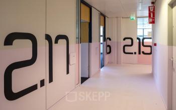 Hal van kantoren in kantoorpand gelegen aan Bruistensingel 500, Den Bosch. De gang is licht met zicht op meerdere kantoorruimtes huren. Vloeren en muren zijn strak afgewerkt met enkele deuren.