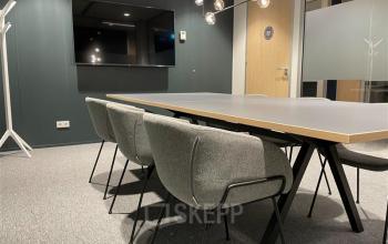 Moderne vergaderruimte in kantoorpand op Alexanderveld 5-9, Den Haag Centrum, met grote tafel, comfortabele stoelen en een flatscreen voor zakelijke bijeenkomsten.
