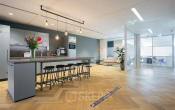 Moderne, lichte kantoorruimte op Alexanderveld 5-9 in Den Haag Centrum met stijlvolle bar, krukken en comfortabele zithoek, geschikt voor veelzijdig gebruik. Ideaal voor wie kantoorruimte wil huren in een centraal gelegen kantoorpand.