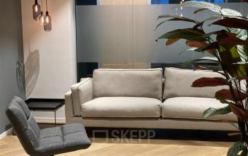 Stijlvolle kantoorruimte aan Alexanderveld 5-9, Den Haag Centrum, met moderne, comfortabele banken en sfeervolle verlichting, perfect voor ontspannen werkbesprekingen of informele interactie.