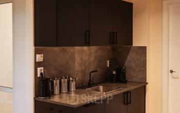 Kleine pantry in een kantoorpand op Zeestraat 100, Den Haag Centrum, met aanrechtblad, spoelbak en koffiezetapparaat.