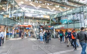 Winkelcentrum in Den Haag met meerdere mensen die door de ruimte lopen en winkelen.